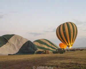 A group of balloons being filled with air. in the air with balloons.