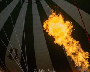 A fire is burning in the sky while inside an air balloon.