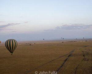 A hot air balloon is flying over the desert.